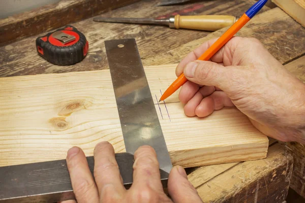 Woodworker ritar en linje på en träskiva — Stockfoto