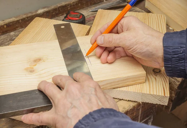Trabalhador desenha uma linha em uma placa de madeira — Fotografia de Stock