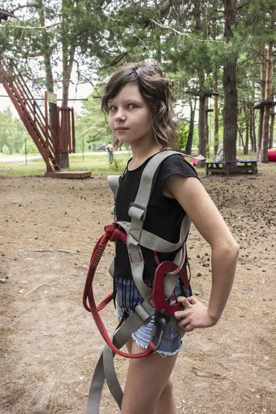 Une fille en tenue de sécurité dans un parc à cordes. Divertissement — Photo