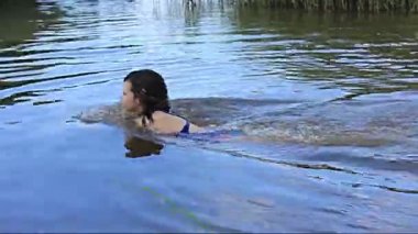 Tatilde. Ağustos. Kız sessiz orman gölünde tek başına banyo yapıyor.