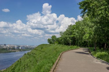 Yaz manzarası. Nehir kıyısında. Güneşli bir yaz günü. Şehir karşı kıyıda.