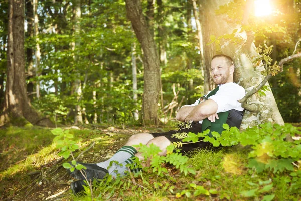 Hombre acostado en el árbol en el bosque — Foto de Stock