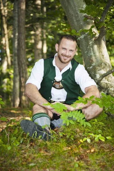 Hombre sentado en el suelo en el bosque — Foto de Stock