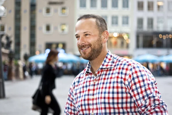 Smiling man with beard in front of city — Stock Photo, Image