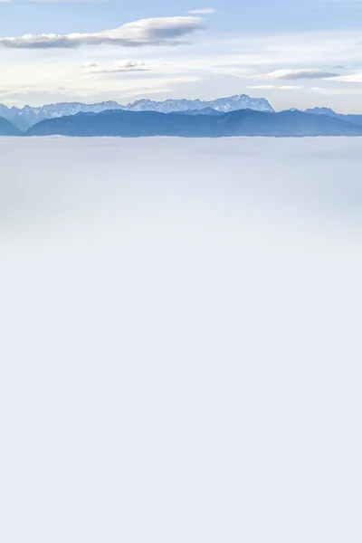 Пейзаж, вкритий туманом з альпами на задньому плані — стокове фото