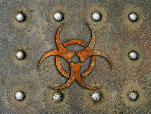 Old rusty iron plate in the form of an armored steel sheet with rivets and an erased mark of the danger of infection — Stock Photo, Image