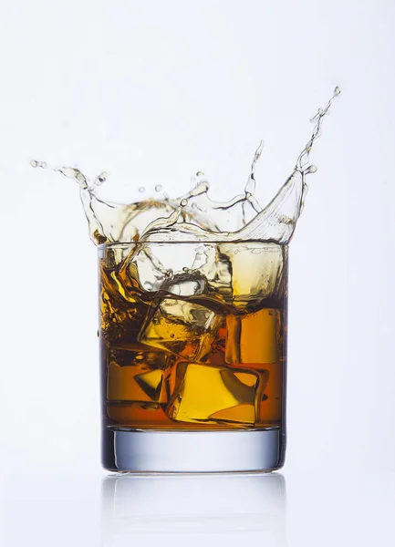 Éclaboussure de whisky en verre Photo De Stock