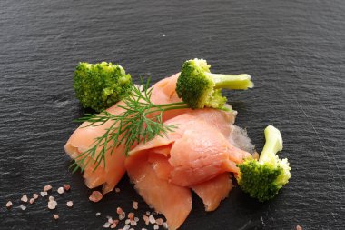 Dereotlu siyah kaplama arkaplanlı füme somon dilimleri