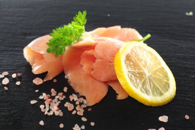 Dereotlu siyah kaplama arkaplanlı füme somon dilimleri