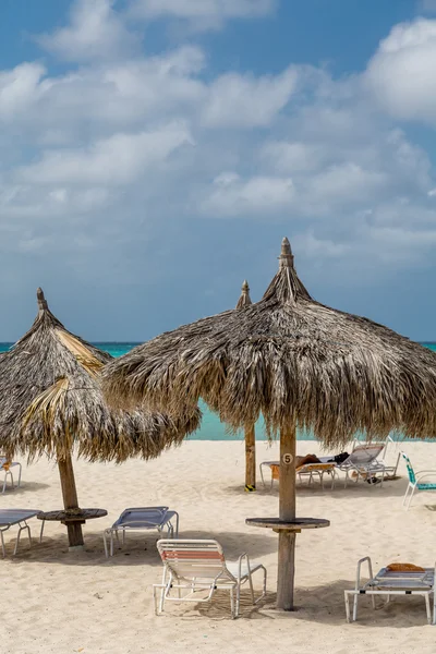Paraguas de paja en la playa de Aruba — Foto de Stock