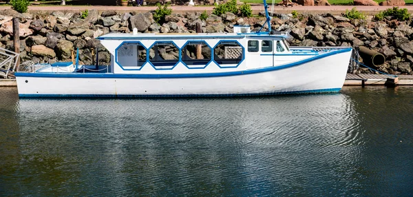 Blauwe en witte boot door Zeedijk — Stockfoto