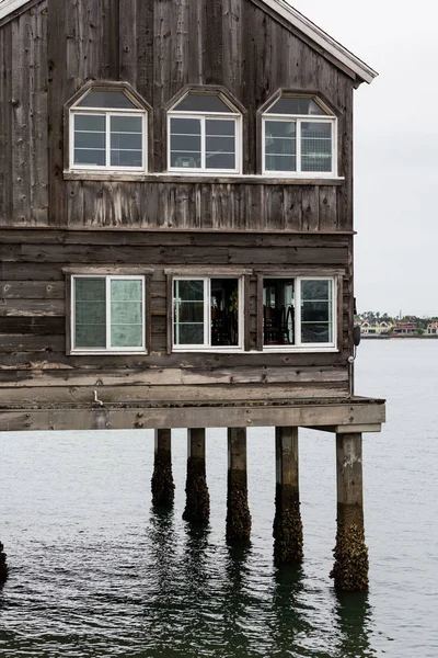 Edificio de madera vieja sobre zancos en el agua —  Fotos de Stock