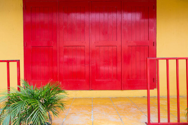 Bright Red doors on yellow plaster wall