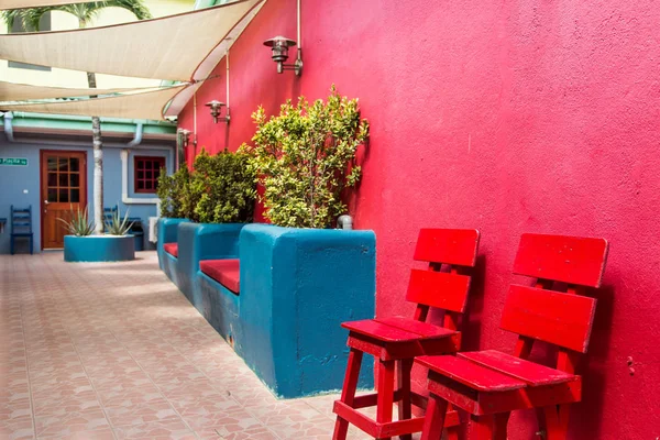 Cadeiras vermelhas e plantador azul — Fotografia de Stock
