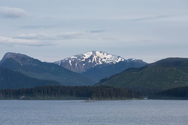 Schneebedeckter Gipfel jenseits der grünen Alaska-Berge — Stockfoto