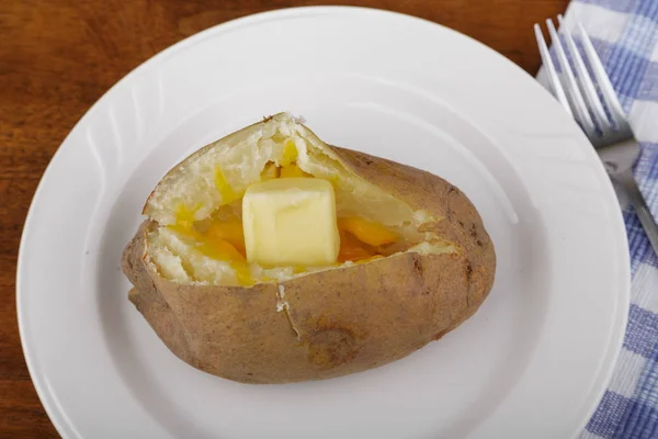 Плавление масла и сыра в печеном картофеле — стоковое фото
