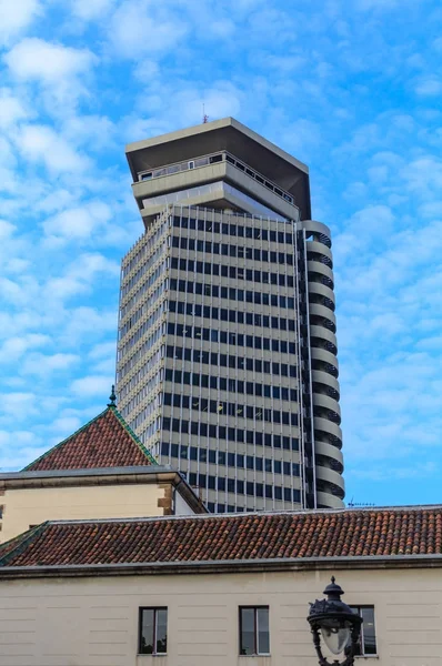 Moderní věž za červenou taškovou střechou — Stock fotografie