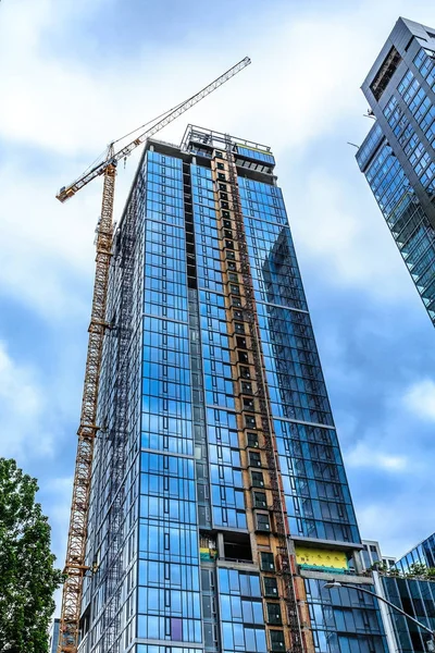 Grúa y elevador en nueva torre de construcción — Foto de Stock