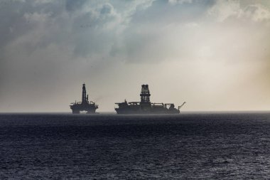 Petrol platformlar üzerinde Sillhouette okyanusta yüzen