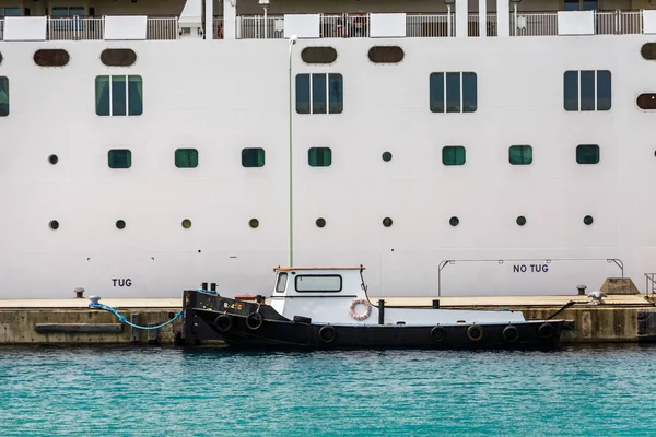 Kleine sleepboot gebonden aan cruiseschip — Stockfoto