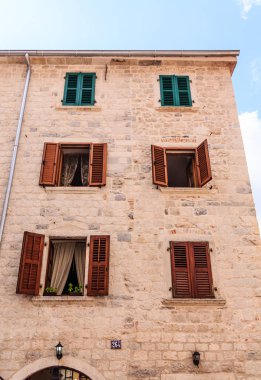 Kırmızı panjurlar ile eski taş bina