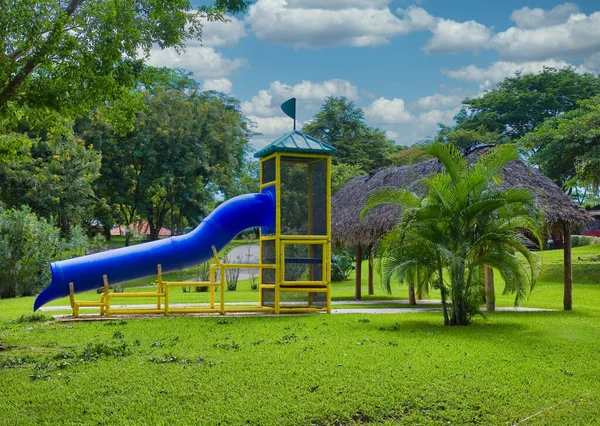 Plac zabaw z niebieską zjeżdżalnią w Tropikach — Zdjęcie stockowe