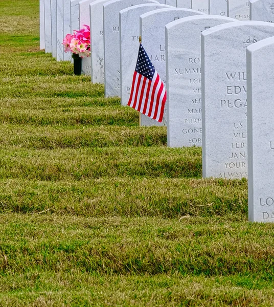Americká vlajka a daffodils u hrobu — Stock fotografie