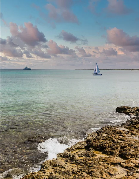 Surf On Rocks with Sailboat at Dusk — Stock Photo, Image