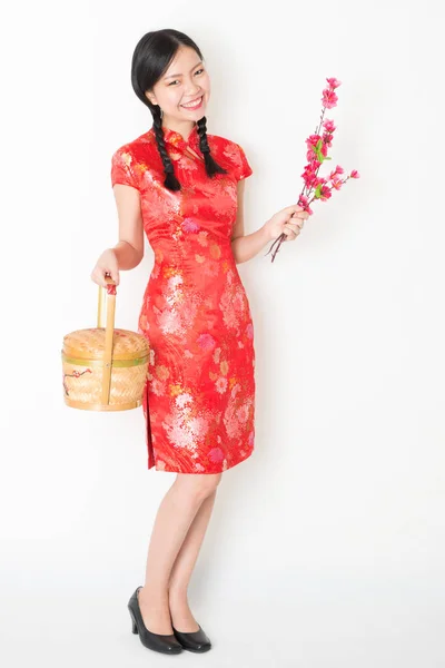 Oriental feminino em vermelho qipao segurando presente cesta — Fotografia de Stock