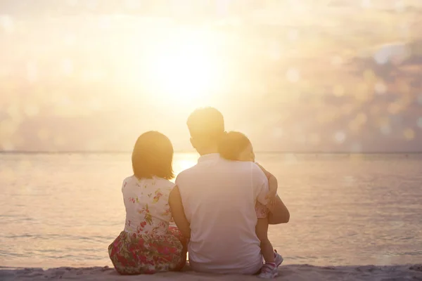 Familie genieten van de zonsondergang aan zee — Stockfoto