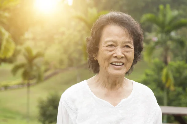 Szczęśliwy seniorów Asian kobieta śmiejąc się na zewnątrz — Zdjęcie stockowe
