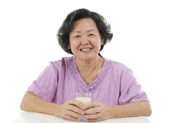 Mujer adulta mayor bebiendo leche — Foto de Stock
