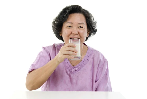 Senior adult woman drinking soy milk — Stock Photo, Image