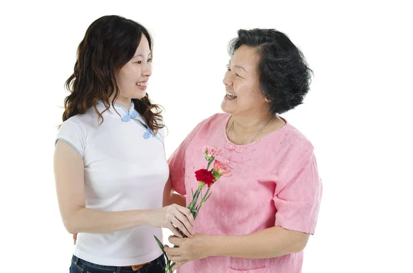 Mère et fille tenant la fleur d'oeillet et souriant — Photo