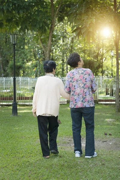 Rear view Asian elderly women walking in park — Stock Photo, Image