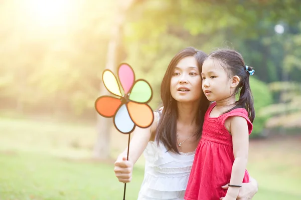 Mutter und Tochter spielen Windmühle im grünen Park. — Stockfoto