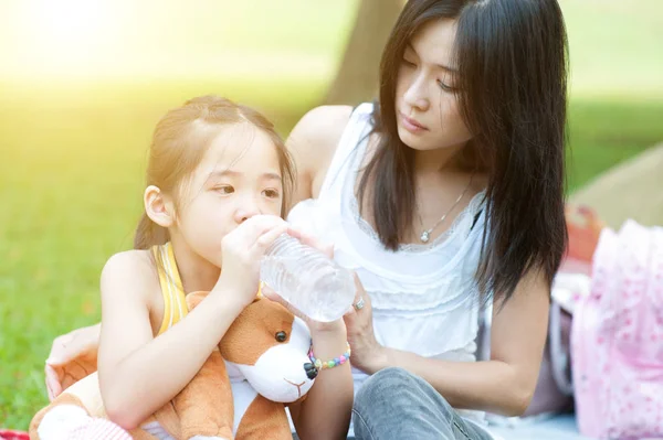 Madre reconfortante niño y agua potable . — Foto de Stock