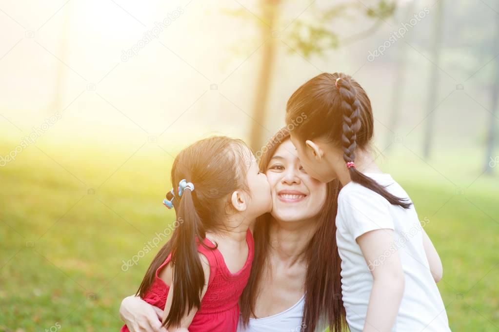 Daughters kissing mother.