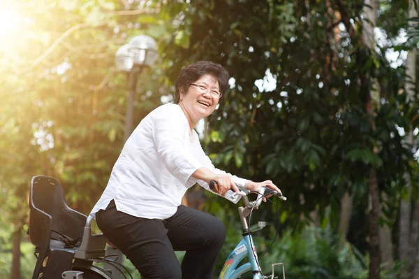 Elderly Asian woman biking — Stock Photo, Image