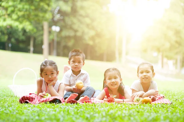 Glada asiatiska barn picknick utomhus. — Stockfoto