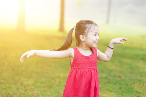 Asiatisches Kind tanzt draußen. — Stockfoto