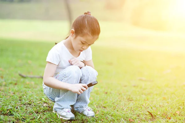 Criança explorando a natureza com lupa ao ar livre . — Fotografia de Stock