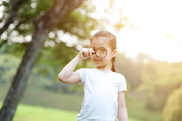 Aziatische meisje verkennen van de natuur met Vergrootglas glas op overtreffen — Stockfoto