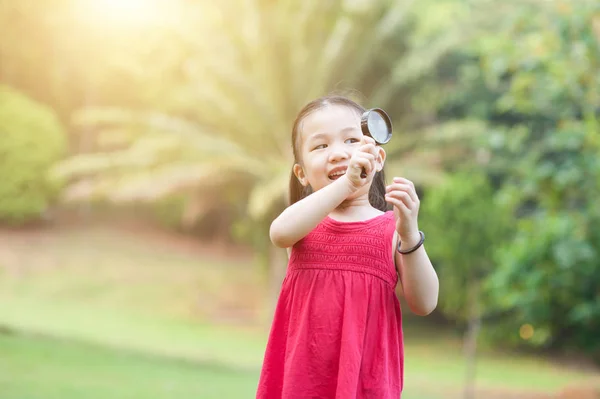 Meisje verkennen van de natuur met Vergrootglas glas in de open lucht. — Stockfoto