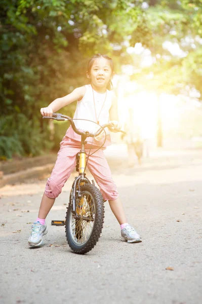 Azjatycki dziecko jazdy na rowerze odkryty. — Zdjęcie stockowe