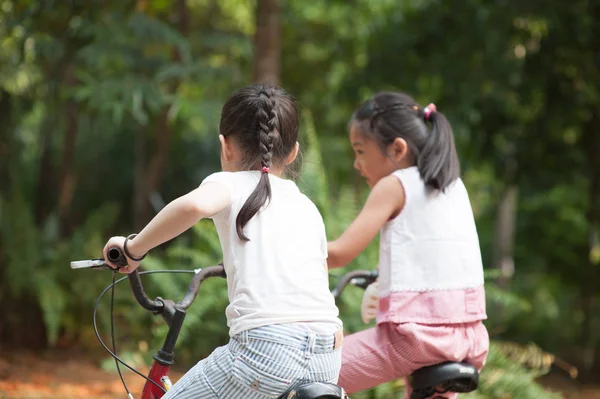 Niños asiáticos activos montar bicicleta al aire libre . —  Fotos de Stock