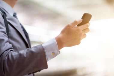 Tren istasyonunda akıllı telefon kullanarak iş adamları.