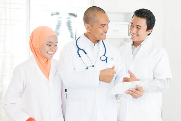 Médicos discutiendo en la tableta PC y pulgares hacia arriba —  Fotos de Stock