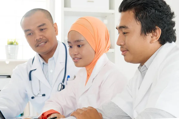 Asiatisches Ärzteteam diskutiert in Krankenhausbüro. — Stockfoto