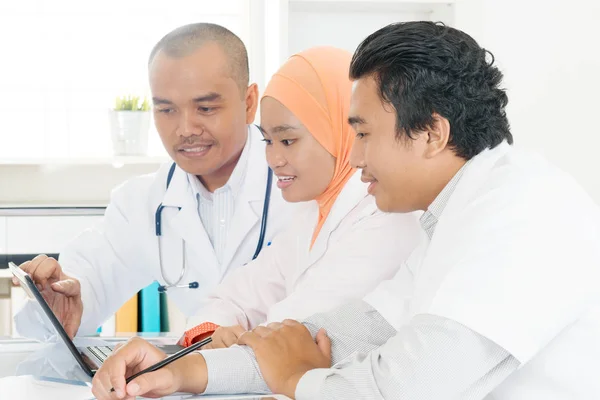 Asiatiska läkare diskuterar på sjukhuset kontor. — Stockfoto